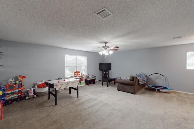 playroom with a textured ceiling, carpet floors, and ceiling fan