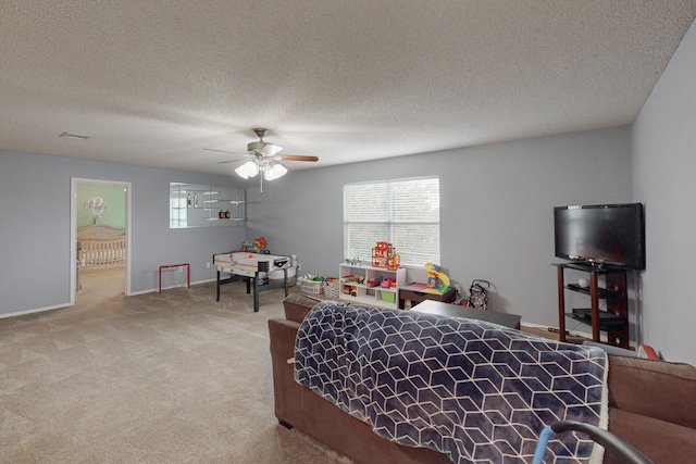 bedroom with ceiling fan, carpet flooring, multiple windows, and a textured ceiling