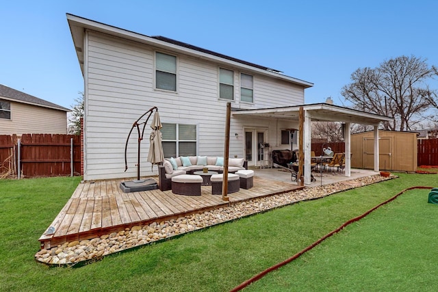 back of house featuring a wooden deck, outdoor lounge area, a yard, and a storage shed