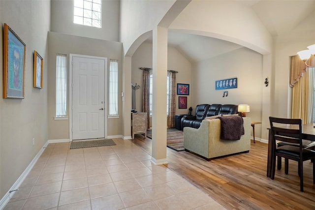 foyer entrance with a towering ceiling and light hardwood / wood-style floors