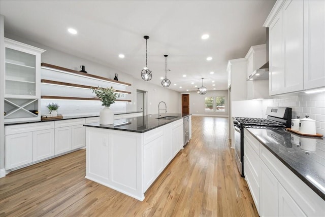 kitchen with pendant lighting, sink, appliances with stainless steel finishes, an island with sink, and white cabinets