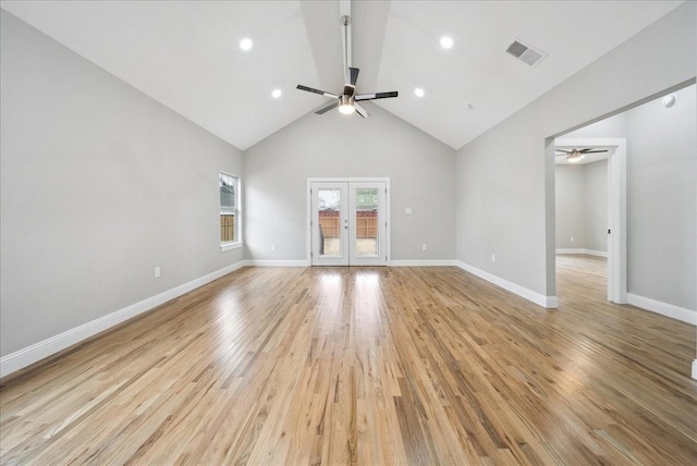 unfurnished living room with ceiling fan, high vaulted ceiling, light hardwood / wood-style floors, and french doors