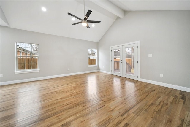 unfurnished living room with beam ceiling, light hardwood / wood-style flooring, french doors, and a healthy amount of sunlight