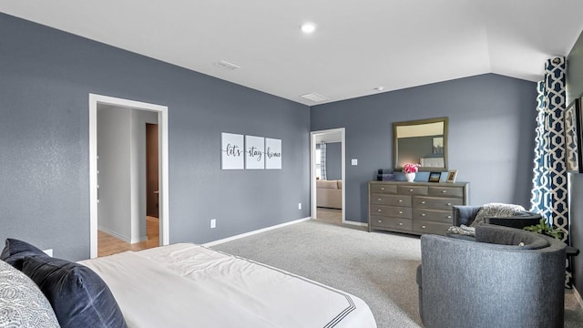 carpeted bedroom with connected bathroom and vaulted ceiling