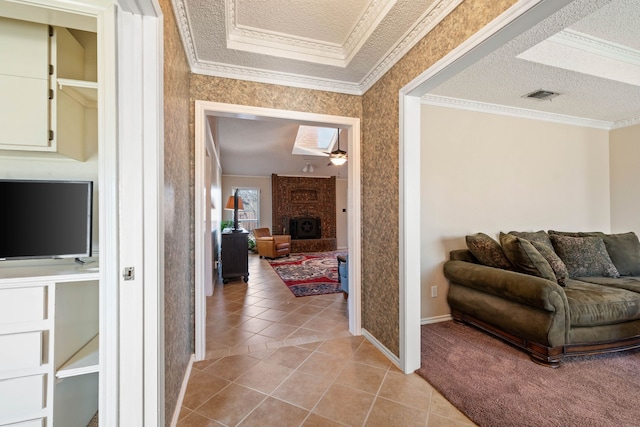 corridor with crown molding, light tile patterned floors, and a textured ceiling