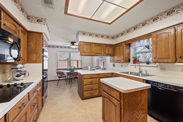 kitchen featuring black appliances, sink, a center island, kitchen peninsula, and a textured ceiling