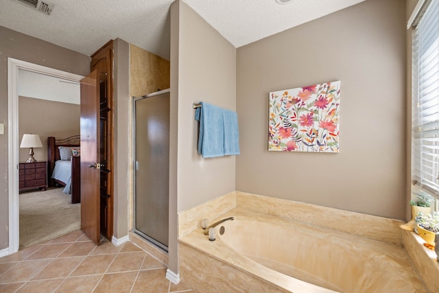 bathroom featuring tile patterned flooring, shower with separate bathtub, and a textured ceiling