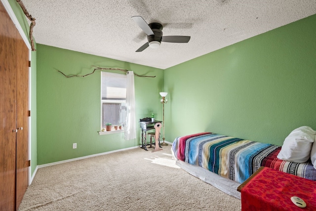 carpeted bedroom with ceiling fan and a textured ceiling