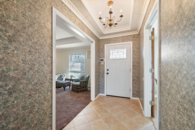 carpeted entrance foyer featuring ornamental molding, a chandelier, and a raised ceiling