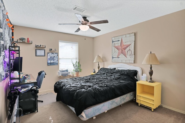 carpeted bedroom featuring ceiling fan and a textured ceiling