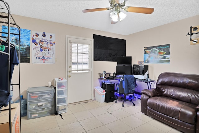 home office with ceiling fan, a textured ceiling, and light tile patterned floors