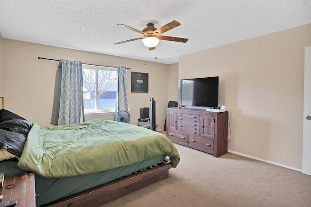 carpeted bedroom with ceiling fan and a textured ceiling