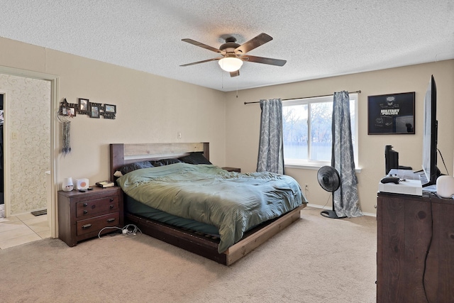 carpeted bedroom featuring ceiling fan and a textured ceiling