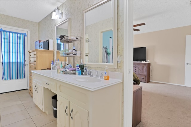 bathroom featuring ceiling fan, vanity, tile patterned flooring, and a textured ceiling