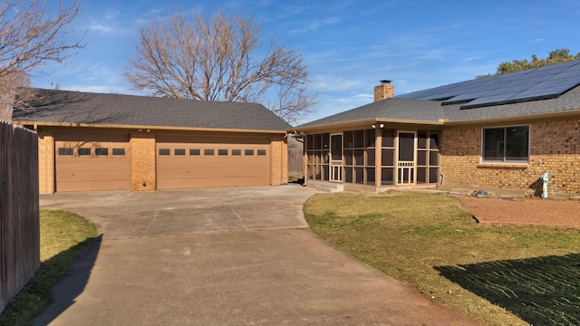 view of front of property featuring a garage, a front yard, and a sunroom