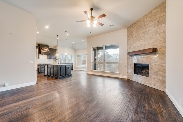 unfurnished living room featuring ceiling fan, dark hardwood / wood-style floors, sink, and a fireplace