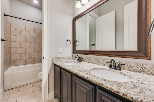 full bathroom with vanity, tiled shower / bath, tile patterned floors, and toilet