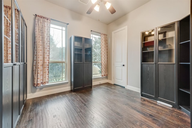 interior space featuring dark wood-type flooring and ceiling fan