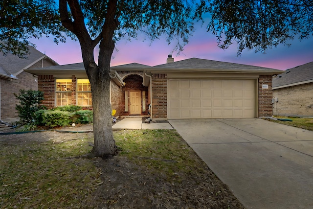 single story home featuring concrete driveway, brick siding, a chimney, and an attached garage