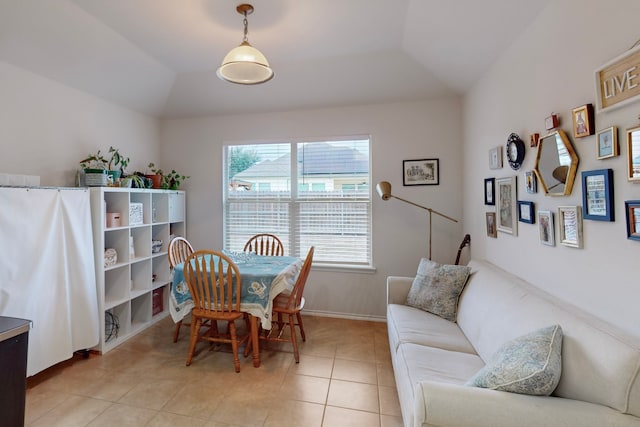 dining area with lofted ceiling, baseboards, and light tile patterned floors