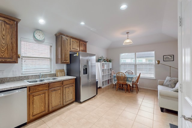 kitchen featuring lofted ceiling, sink, hanging light fixtures, light tile patterned floors, and appliances with stainless steel finishes