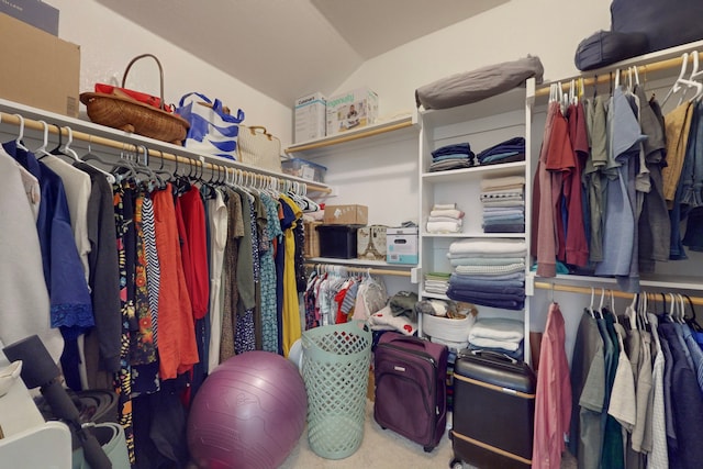 walk in closet featuring carpet and vaulted ceiling