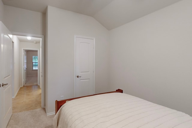 bedroom with light carpet and vaulted ceiling