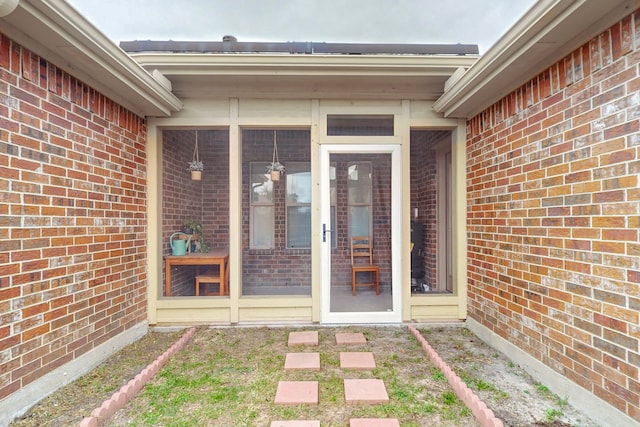 doorway to property with brick siding