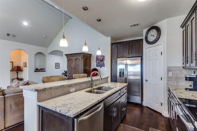 kitchen featuring pendant lighting, sink, appliances with stainless steel finishes, a kitchen island with sink, and dark brown cabinetry