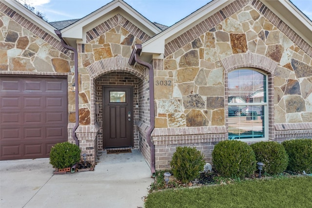 3032 James Ave, Fort Worth, TX 76110 - property entrance featuring stone siding, an attached garage, and concrete driveway