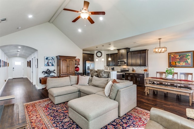 living room with ceiling fan with notable chandelier, high vaulted ceiling, dark hardwood / wood-style floors, and beamed ceiling