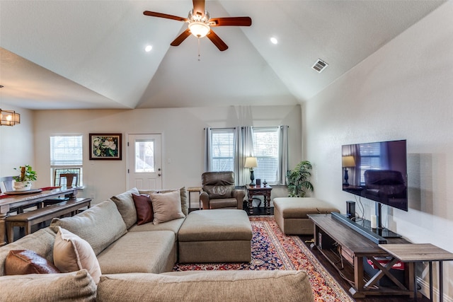 living room featuring high vaulted ceiling, ceiling fan with notable chandelier, and hardwood / wood-style floors