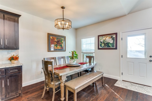 dining area with dark hardwood / wood-style flooring and a notable chandelier