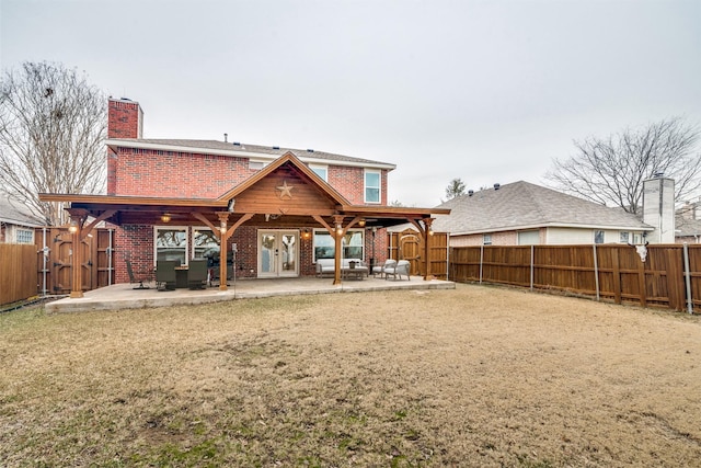 back of house with french doors, a lawn, and a patio area