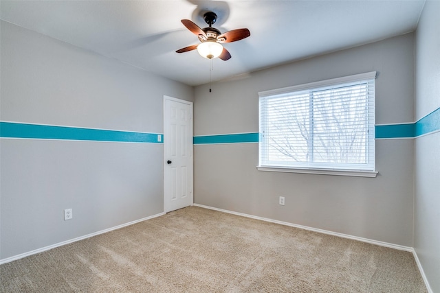 spare room featuring light colored carpet and ceiling fan