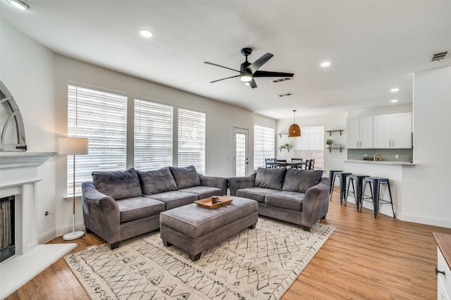 living room featuring ceiling fan and light hardwood / wood-style flooring