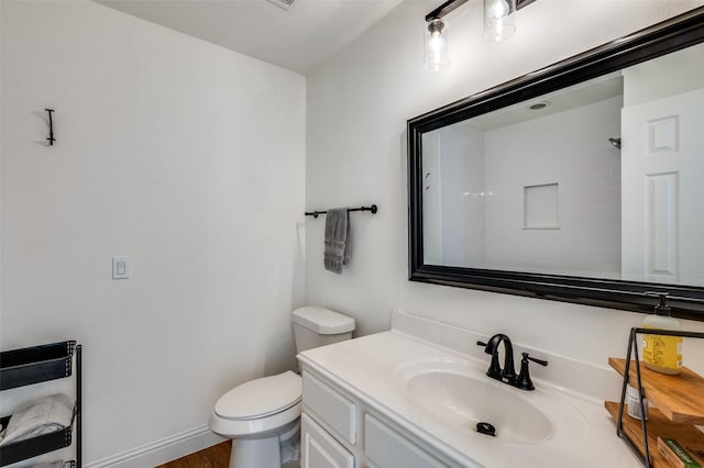 bathroom featuring walk in shower, vanity, and toilet