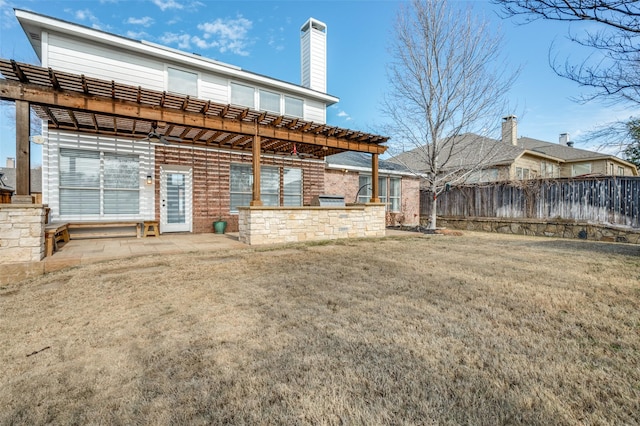 rear view of property featuring area for grilling, a lawn, and a patio