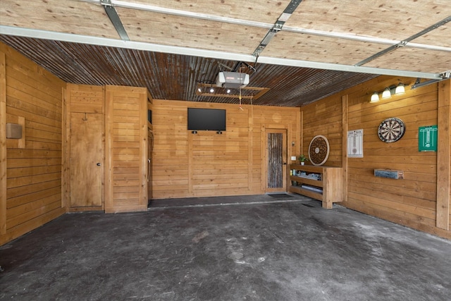 garage with a garage door opener and wood walls