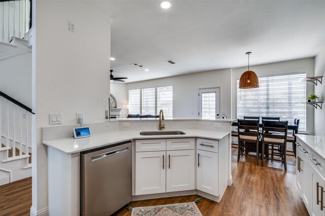 kitchen with sink, light stone counters, appliances with stainless steel finishes, light hardwood / wood-style floors, and white cabinets