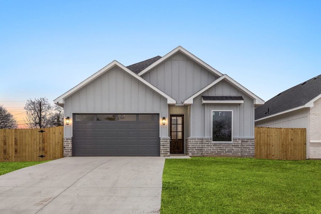 view of front of home with a garage and a yard