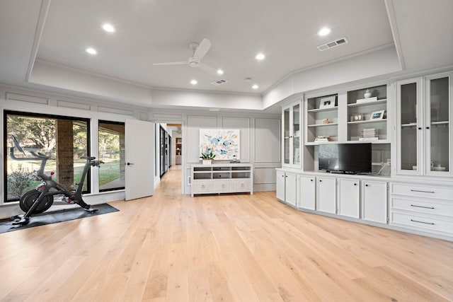 unfurnished living room featuring a tray ceiling, light hardwood / wood-style flooring, and ceiling fan