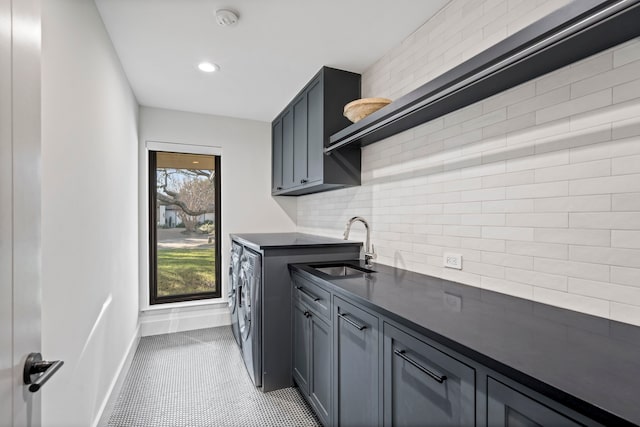 clothes washing area with cabinets, sink, and washing machine and dryer