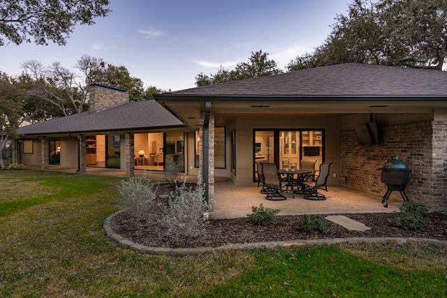 back of property featuring a yard and a patio