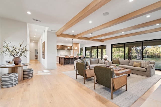 living room with beam ceiling and light hardwood / wood-style floors