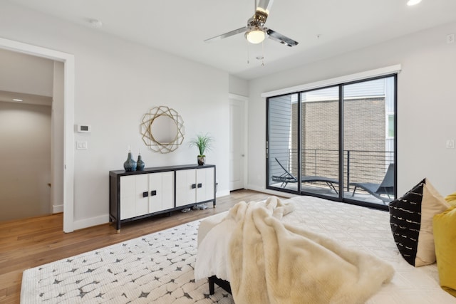 bedroom featuring access to exterior, hardwood / wood-style floors, and ceiling fan