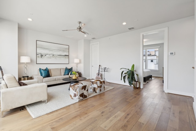 living room with wood-type flooring and ceiling fan