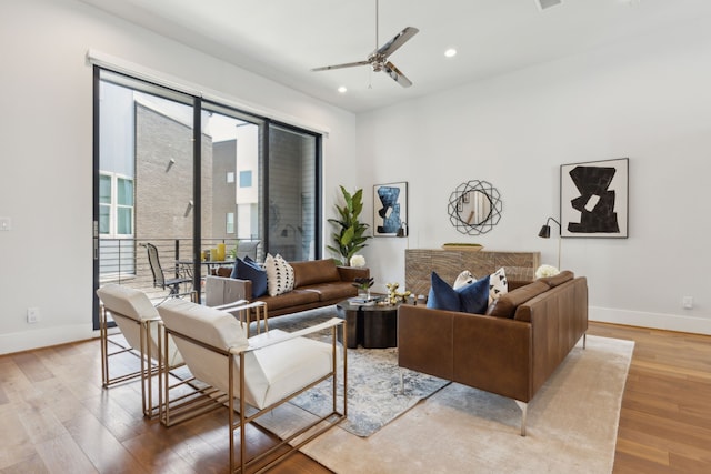 living room with light hardwood / wood-style flooring and ceiling fan