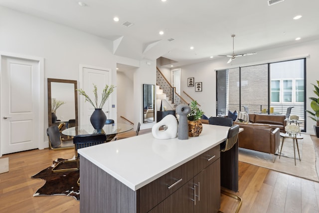 kitchen with a center island, dark brown cabinets, and light hardwood / wood-style floors