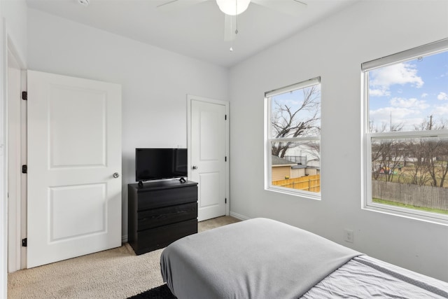 bedroom featuring light carpet and multiple windows